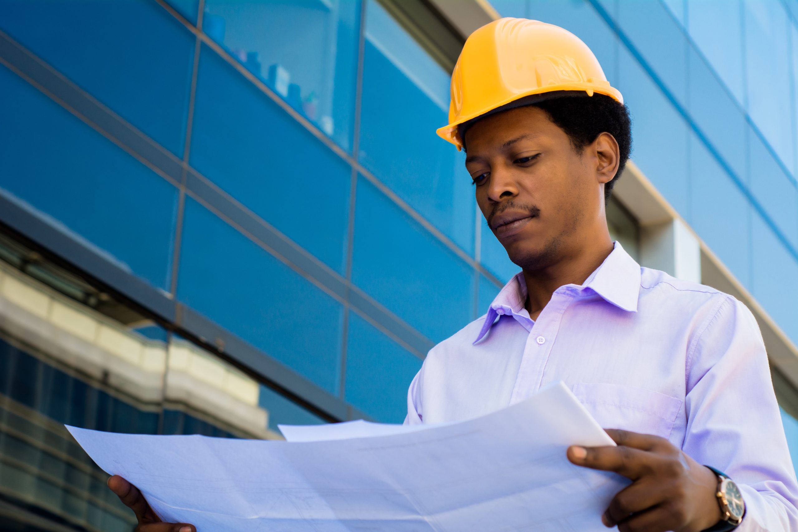 professional architect holding blueprints outdoors.